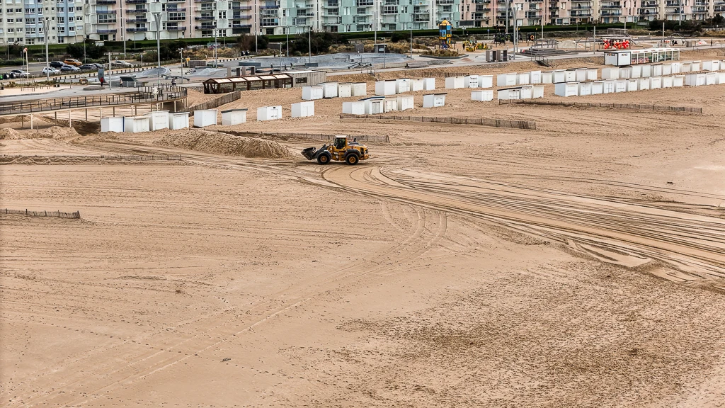 Un bolldozer en cours de renivelage du sable de Calais la Plage
